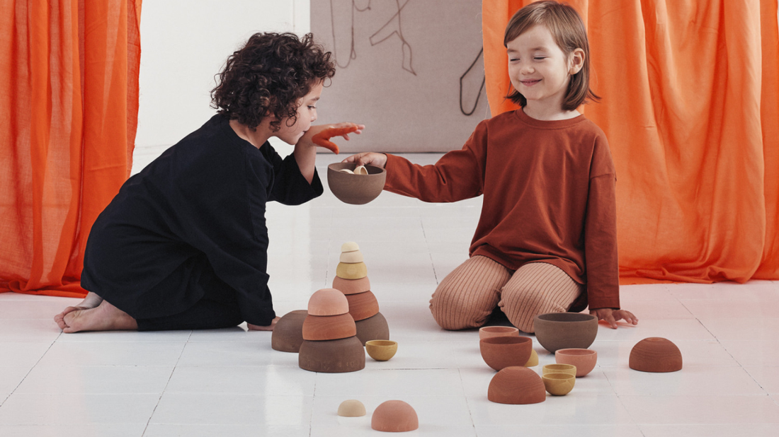 Child engaged with Raduga Grez wooden toys, a blend of craftsmanship and nature.